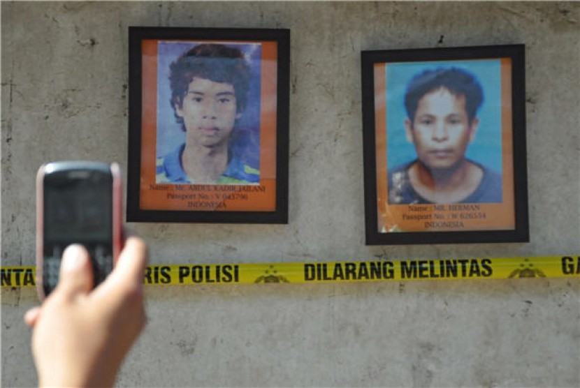 Seseorang mengambil gambar foto TKI korban dugaan praktik jual-beli organ tubuh di lokasi autopsi di pemakaman Dusun Pancor Kopong, Lombok Timur, NTB, Kamis (26/4). 