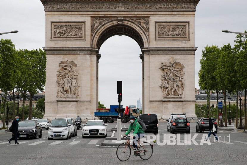Seseorang mengendarai sepedanya di depan Arc de Triomphe, Paris, Senin (11/5). Prancis mulai kembali mengizinkan  aktivitas diluar rumah  pada tanggal 11 Mei 2020 usai menjalani masa lockdown selama dua bulan sebagai upaya menekan penyebaran COVID-19. 