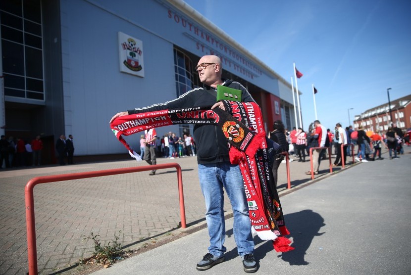 Seseorang menjual syal jelang laga Southampton lawan Manchester United di depan Stadion Saint Mary's, Sabtu (23/9). 