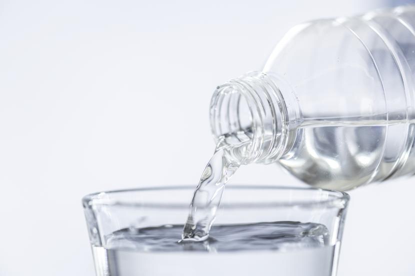 Seseorang menuangkan air minum ke dalam gelas. Asosiasi Industri memperingatkan bahwa krisis energi bisa saja mengancam pasokan air minum di Jerman.