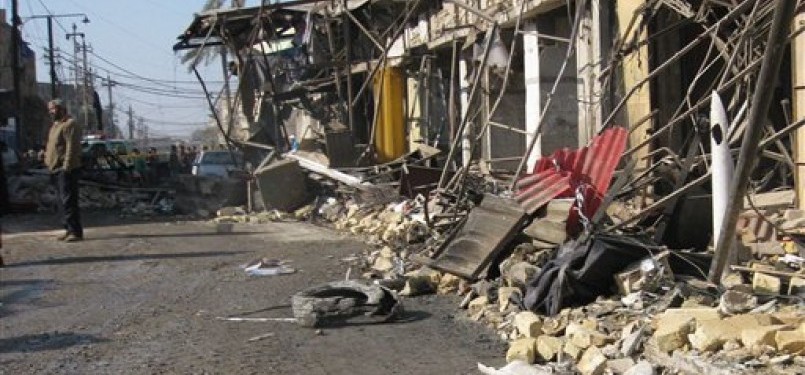 Seseorang pria tengah berdiri di sekitar lokasi ledakan bom di Kazimiyah, utara Baghdad, Kamis (5/1).