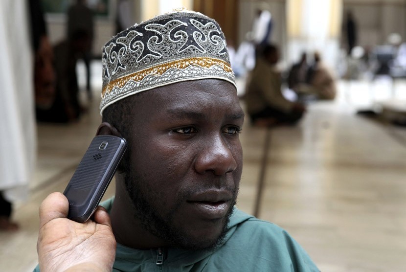   Sharif Ismail menerima panggilan di telepon genggamnya saat menunggu shalat Jumat di masjid Jami kota Nairobi, Kenya Jumat (10/8). (Noor Khamis/Reuters)