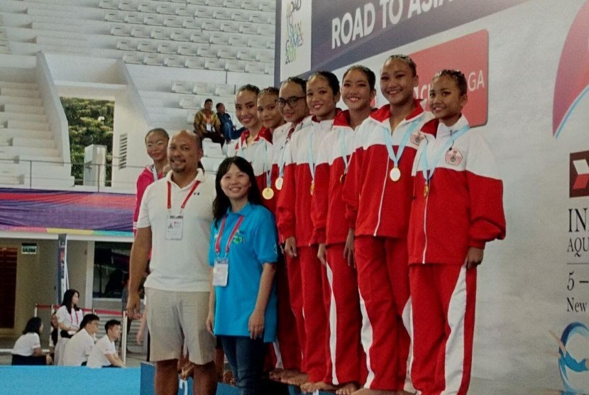 Shelvy Melowa depan baju biru (manajer kompetisi renang artistik) berpose bersama pemenang renang artistik.