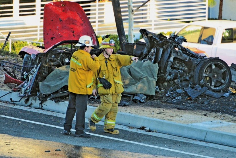 Sheriff's deputies work near the wreckage of a Porsche that crashed into a light pole on Hercules Street near Kelly Johnson Parkway in Valencia, Calif., on Saturday, Nov. 30, 2013. 