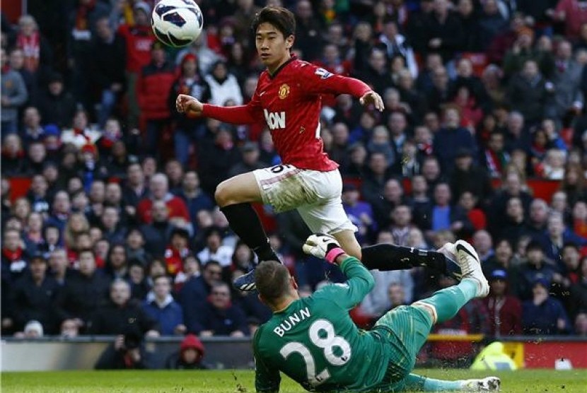 Shinji Kagawa (kiri), pemain Manchester United, mencetak gol usai memperdayai kiper Norwich City, Mark Bunn, dalam laga Liga Primer Inggris di Old Trafford, Manchester, Sabtu (2/3). 