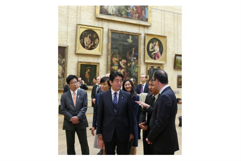 Shinzo Abe mendengarkan penjelasan dari Presiden Museum Louvre, Paris, Ahad (4/5).