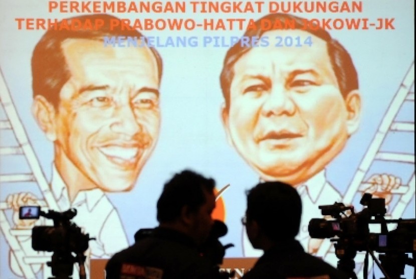 Siluet juru kamera berlatar belakang layar monitor yang menunjukkan hasil suvei Lemabag Survei Nasional (LSN) mengenai elektabilitas calon presiden dan calon wakil presiden di Jakarta, Kamis (12/6). 
