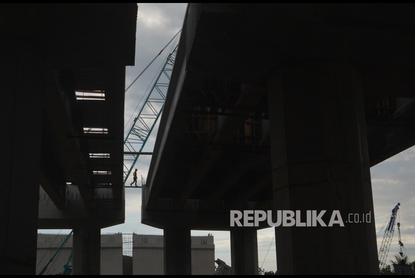 Siluet pekerja melintas di proyek pembangunan jembatan layang Tol Padang - Pekanbaru di Jalan Raya Padang - Bukittinggi, Pasar Usang, Kabupaten Padangpariaman, Sumatera Barat (ilustrasi)