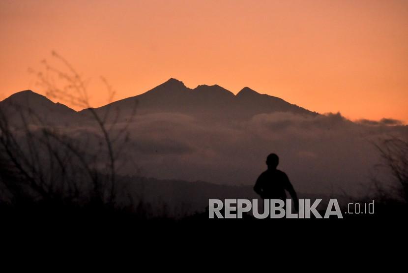 Siluet puncak Gunung Rinjani terlihat jelas saat matahari terbit dari Kota Mataram, NTB, Sabtu (14/8/2021). 