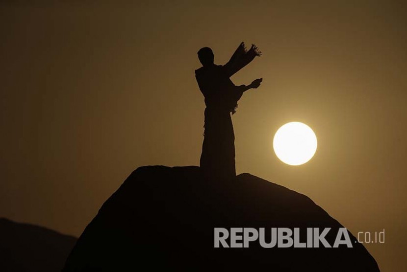 Siluet seorang jamaah haji di Jabal Rahmah melaksanakan wukuf di Padang Arafah, Ahad pagi (11/9).
