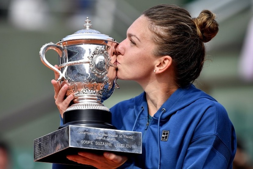 Simona Halep mencium trofi juara Grand Slam Prancis Terbuka 2018.