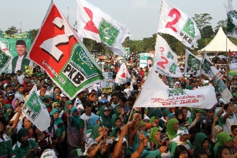 Simpatisan Partai Kebangkitan Bangsa (PKB) membawa atribut partai ketika kampanye 