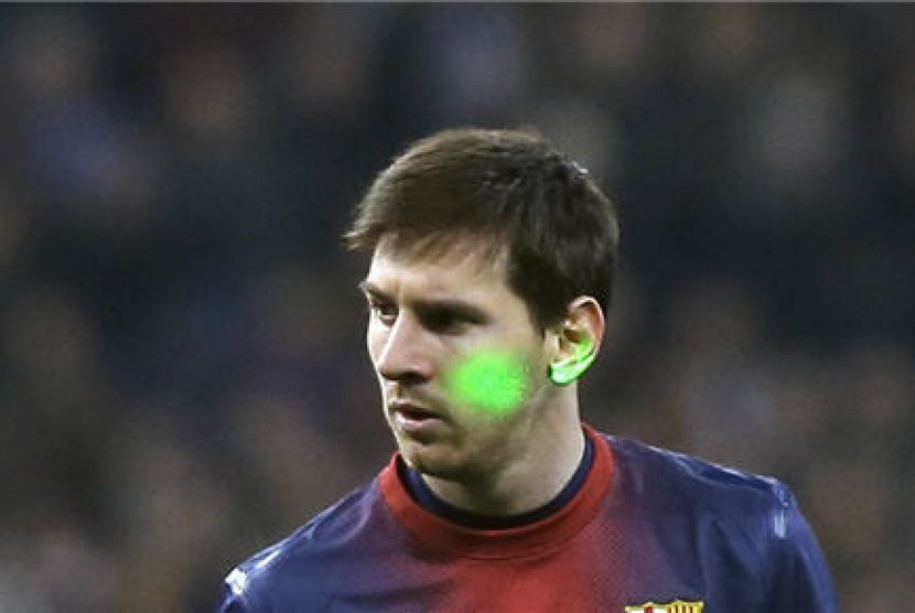 Sinar laser ditembakan ke wajah Lionel Messi, striker Barcelona, saat menghadapi Real Madrid di laga semifinal Copa del Rey di Stadion Santiago Bernabeu, Madrid, Rabu (30/1). 