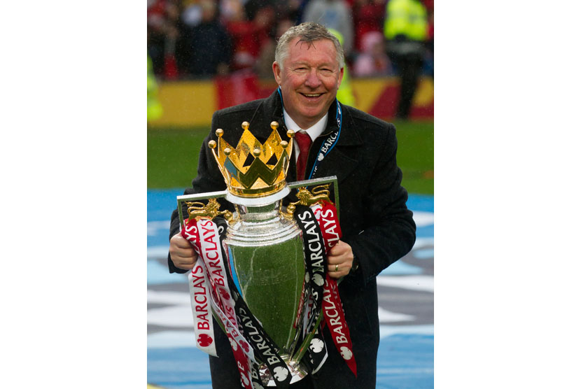  Sir Alex Ferguson memegang trofi Liga Primer Inggris setelah pertandingan kandang terakhir melawan Swansea City, di Stadion Old Trafford, Manchester, Ahad (12/5).   (AP/Jon super)