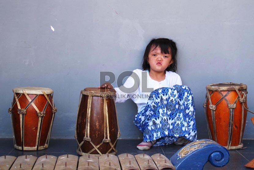 Siswa anak berkebutuhan khusus (ABK) duduk diantara alat kesenian musik tradisi.