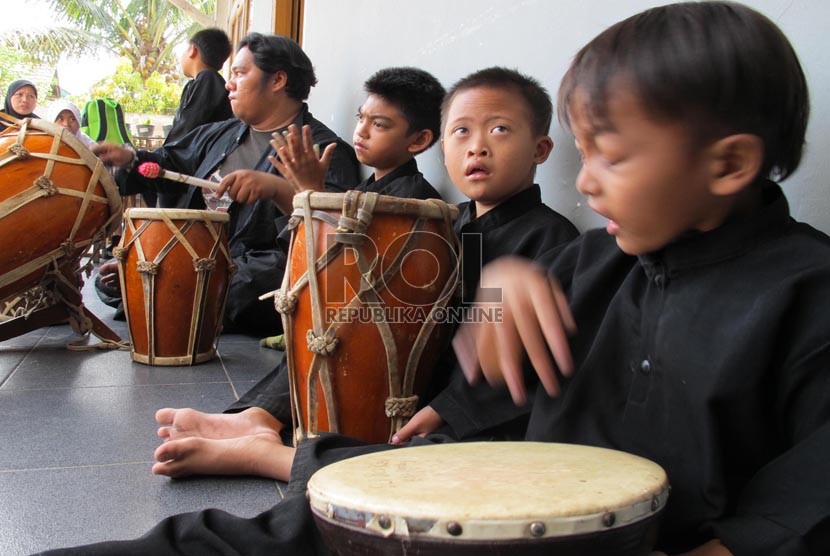 Siswa anak berkebutuhan khusus (ABK) duduk diantara alat kesenian musik tradisi saat bersiap mengikuti pelajaran seni musik di sekolah luar biasa (SLB) Bina Kasih, Ciwastra, Kota Bandung, Rabu (12/8).  (foto : Septianjar Muharam)