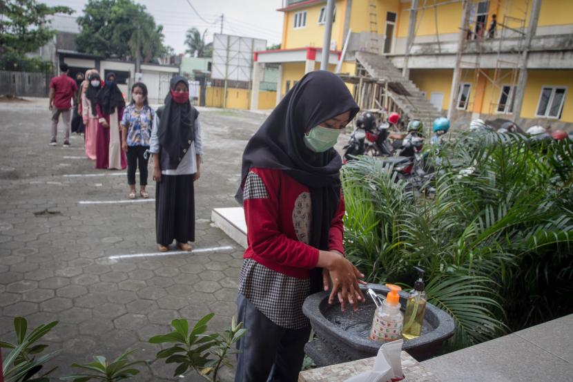 Siswa baru mencuci tangan sebelum berada di lingkungan sekolah saat Simulasi Normal Baru di SMK Kesehatan Mandala Bhakti, Solo, Jawa Tengah.