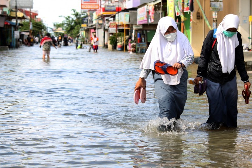 Siswa berusaha menerobos banjir yang merendam kawasan Pondok Ungu Permai, Bekasi, Jawa Barat, Kamis (25/2). 