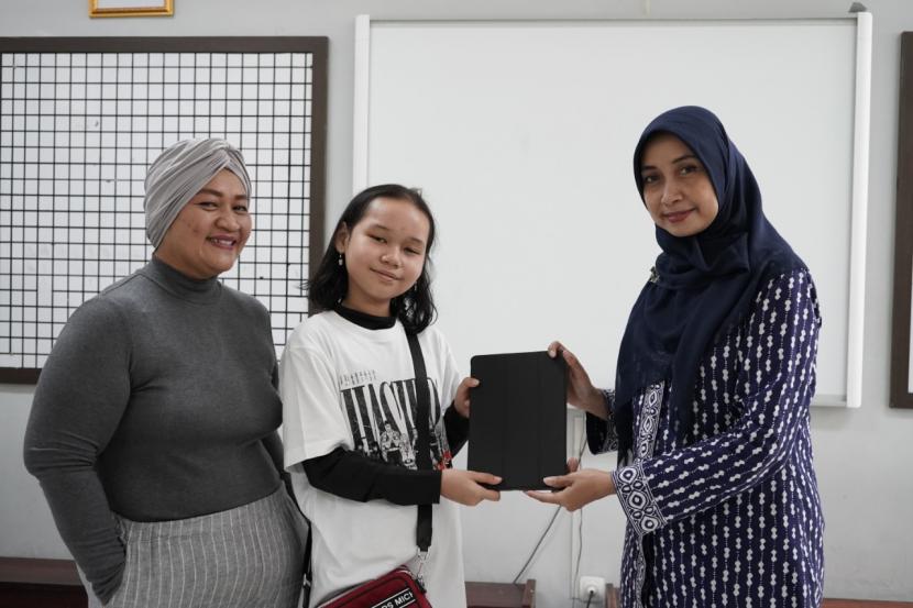 Siswa didampingi orang tua siswa kelas VII SMP Bakti Mulya 400 Jakarta datang bergiliran untuk mendapatkan iPad dari sekolah.