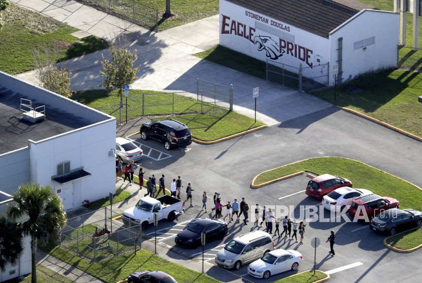 Siswa dievakuasi oleh polisi dari Marjory Stoneman Douglas High School di Parkland, Florida, pada hari Rabu (14/2), setelah seorang penembak melepaskan tembakan ke kampus.