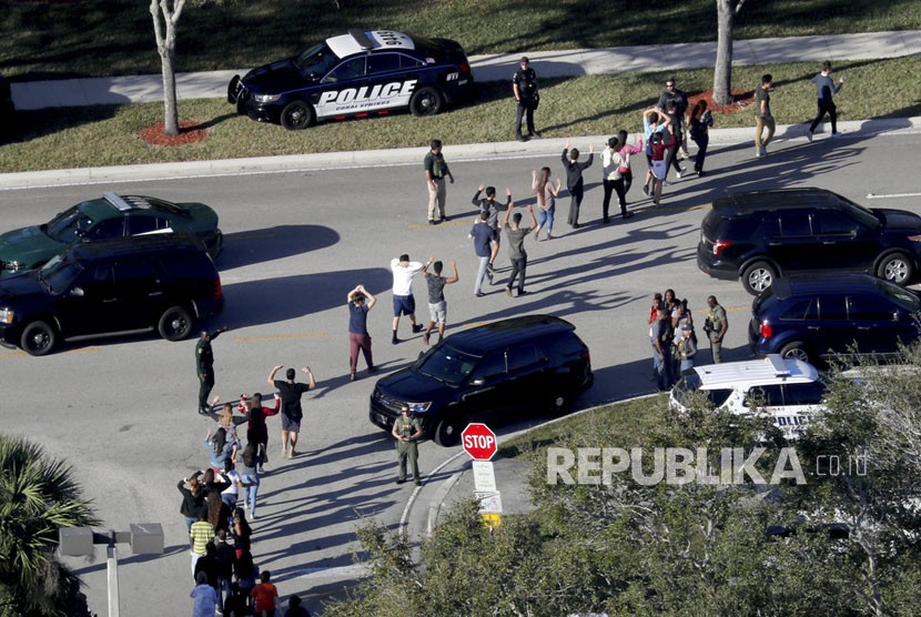 Siswa dievakuasi oleh polisi dari Marjory Stoneman Douglas High School di Parkland, Florida, pada hari Rabu (14/2), setelah seorang penembak melepaskan tembakan ke kampus.