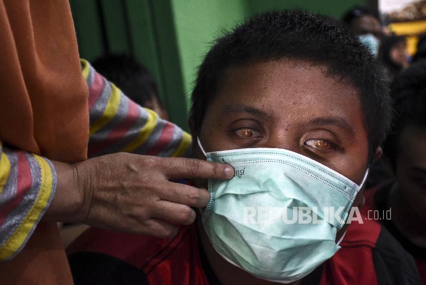 Siswa disabilitas netra didampingi guru mempraktikan cara menggunakan masker yang benar saat Sosialisasi Simulasi Pencegahan Penyebaran Virus Corona di SLBN A Pajajaran, Kota Bandung, Jumat (6/3).