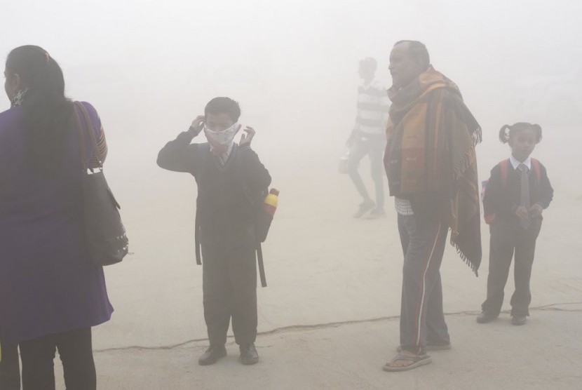 Siswa India menggunakan sapu tangan sebagai masker untuk melindungi diri dari polusi udara mematikan di New Delhi, India.