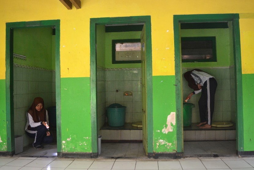 Siswa Jumantik melakukan pemberantasan jentik di dalam bak mandi SMPN 2 Jombang, Jawa Timur, Jumat (8/2/2019).