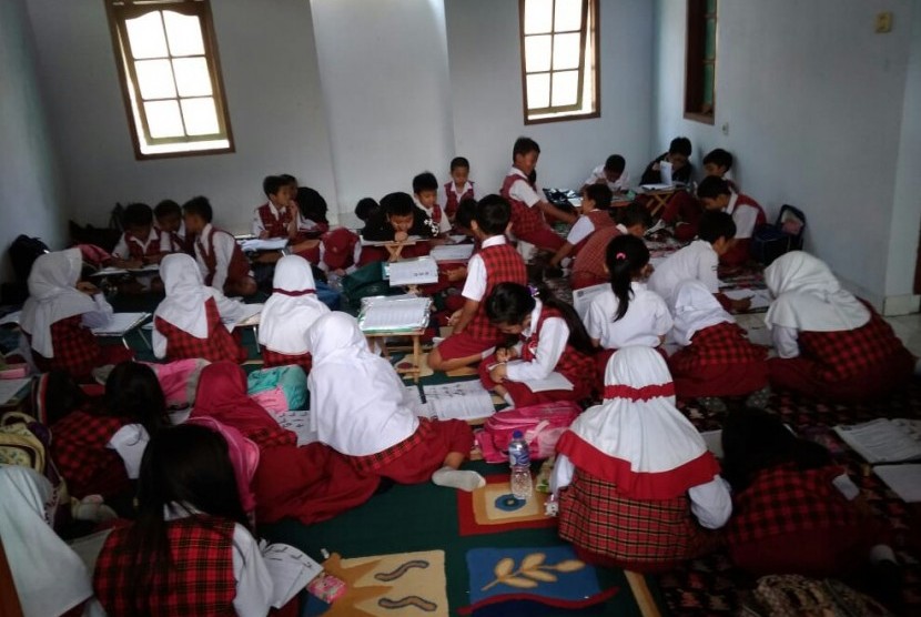 Siswa kelas 2 SDN 106 Ajitunggal 106, Jalan Terusan Sukup No 5, Kelurahan Pasirendah, Kecamatan Ujungberung, Kota Bandung, terpaksa mengikuti kegiatan belajar-mengajar di rumah warga sekitar sekolah, Senin (8/4).