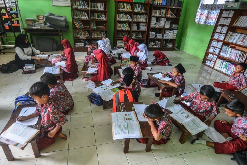 Siswa kelas dua Sekolah Dasar Negeri (SDN) Cikadongdong mengikuti Kegiatan Belajar Mengajar (KBM) di lantai ruang perpustakaan di Singaparna, Kabupaten Tasikmalaya, Jawa Barat, Rabu (17/7/2018). 