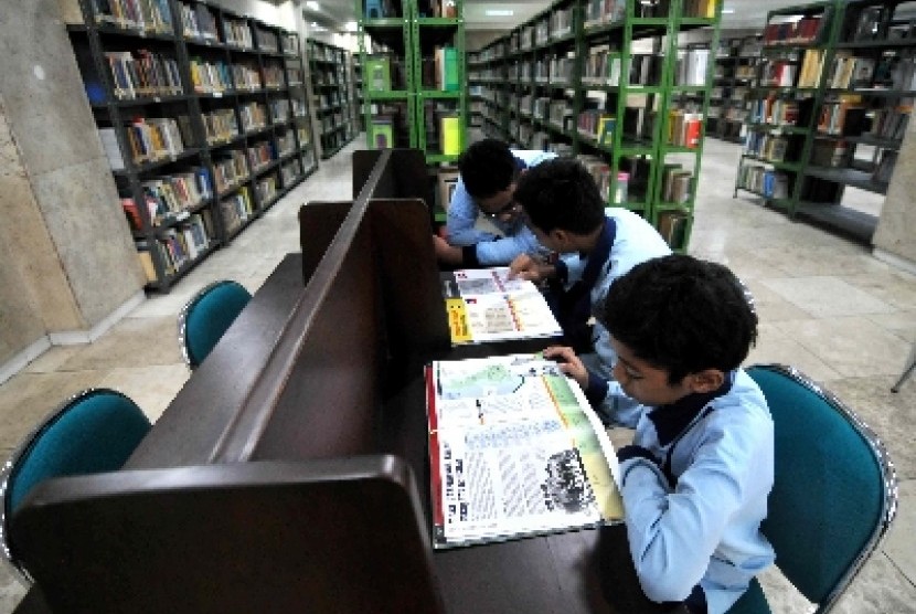 Siswa madrasah membaca buku di perpustakaan.