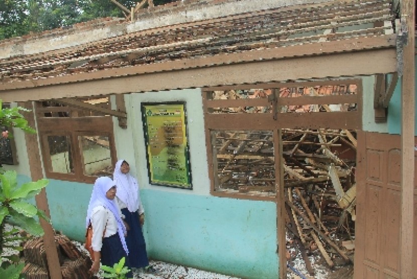 Siswa Madrasah Tsanawiyah (MTs) Nurul Falah di Serang, Banten memandangi bagian sekolah mereka yang rusak berat.