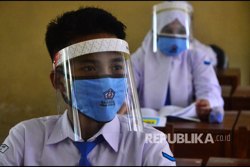 Siswa memakai face shield dan masker saat mengikuti uji coba Pembelajaran Tatap Muka (PTM). Ilustrasi