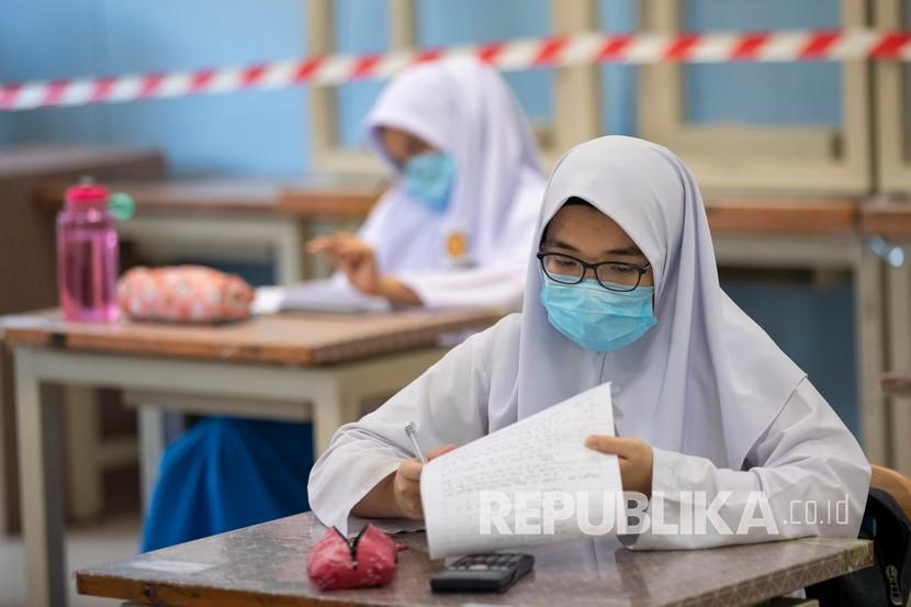 Siswa mengenakan masker dan menjaga jarak sosial di ruang kelas selama hari pertama sekolah dibuka kembali di sebuah sekolah menengah di Putrajaya, Malaysia, Rabu (24/6/2020). Malaysia mempertimbangkan untuk mewajibkan pemakaian masker di ruang publik. Ilustrasi. 