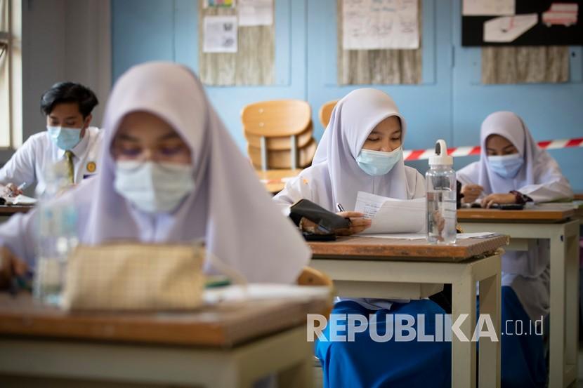 Siswa mengenakan masker dan menjaga jarak sosial di ruang kelas saat hari pertama sekolah dibuka kembali di sebuah sekolah menengah di Putrajaya, Malaysia, Rabu (24/6/2020). Malaysia mencatat penambahan kasus Covid-19 terbanyak berasal dari klaster pusat tahanan sementara dan penjara.