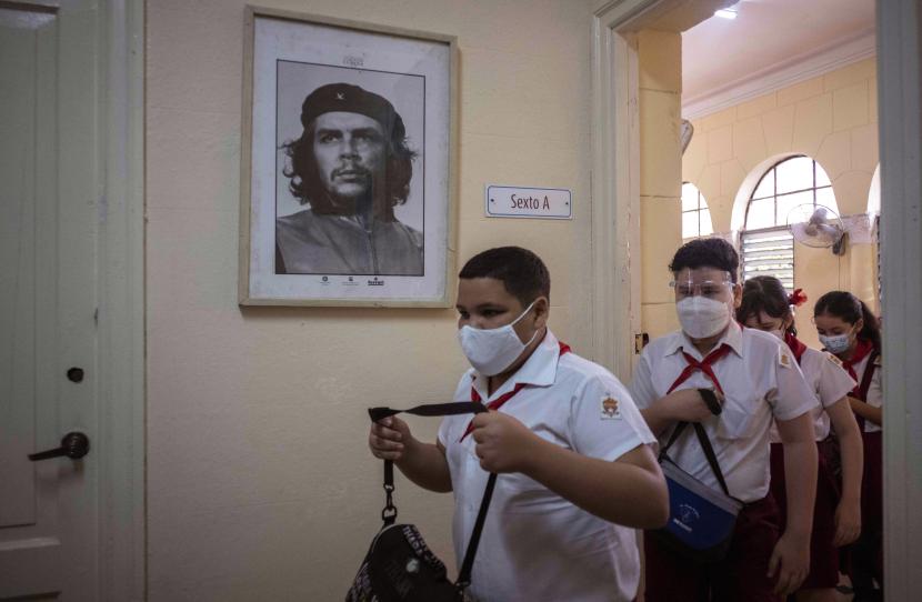 Siswa mengenakan masker sebagai tindakan pencegahan di tengah penyebaran COVID-19 menghadiri hari pertama sekolah mereka setelah berbulan-bulan tanpa kelas tatap muka di Havana, Kuba, Senin, 8 November 2021. Kuba kini memasuki era normal baru, Kuba juga telah mencabut pembatasan internasional.