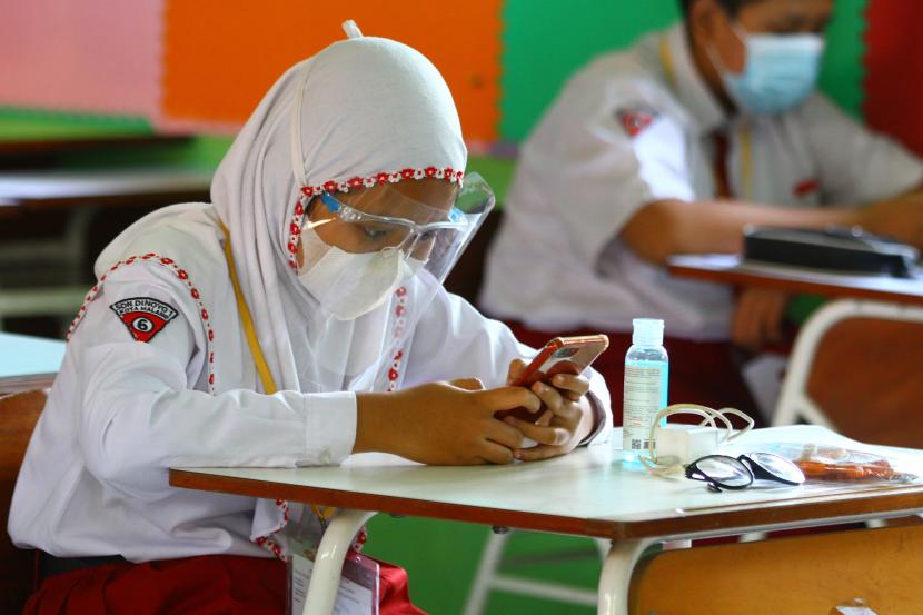 Siswa mengerjakan soal PPKn melalui gawai dalam Ujian Sekolah yang diadakan secara tatap muka di SDN Dinoyo 1 Malang, Jawa Timur, Senin (26/4/2021). Ujian sekolah sebagai salah satu syarat kelulusan tersebut diadakan serentak secara tatap muka di 250 sekolah dasar negeri maupun swasta di Kota Malang.