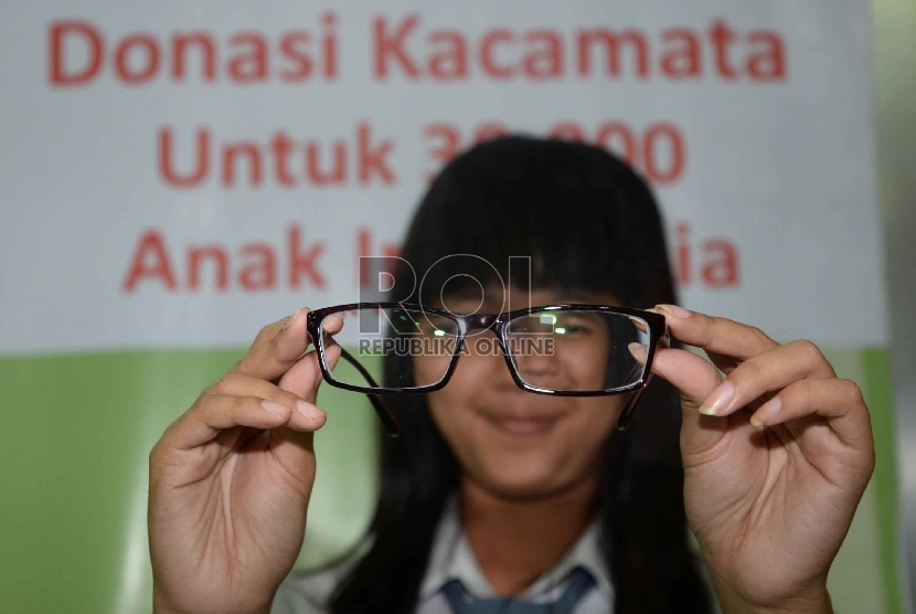 Siswa menunjukkan kacamata usai penerimaan donasi kacamata untuk Anak Indonesia di Aula Al-Amanah, Gedung Pusat Pemerintah Kota Tangerang, Banten, Selasa (22/9).