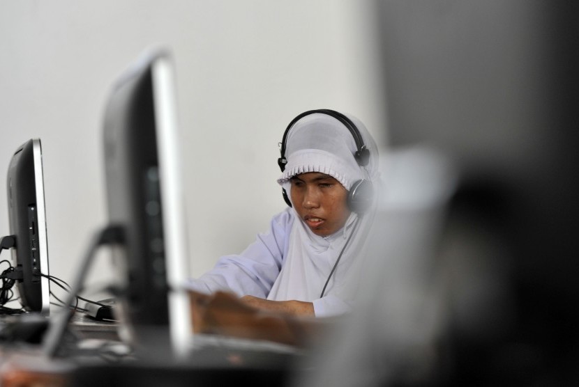 Siswa penyandang cacat tunanetra mendengarkan soal ujian dari komputer saat mengikuti Ujian Akhir Sekolah (UAS) tinggat SD di SLBA Yapti Makassar, Sulawesi Selatan, Senin (25/4).