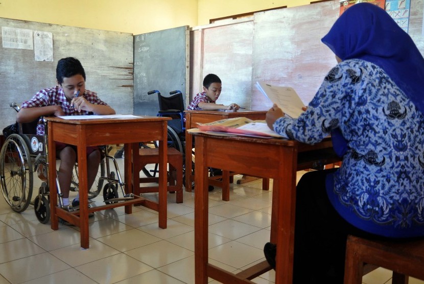 Siswa penyandang tuna daksa mengerjakan soal saat Ujian Sekolah (US) tahun ajaran 2014/2015 pada hari ketiga di SDLB Negeri Temanggung, Jawa Tengah, Rabu (20/5). 