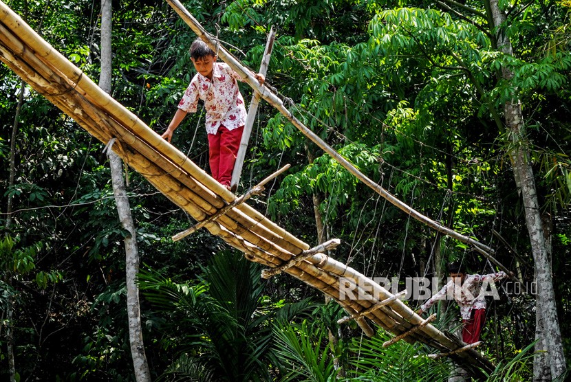 Siswa SD melintasI jembatan bambu yang rusak di Kampung Cigedang, Desa Leuwiipuh, Lebak, Banten, Rabu (30/10/2019).