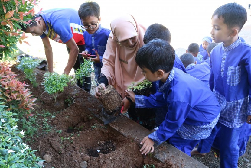 Siswa SD Quran Ar Risalah belajar menanam pohon.