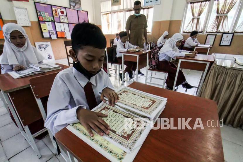 Siswa SDN 1 Lhokseumawe membaca Al Quran pada hari pertama sekolah di bulan Ramadhan 1443 Hijriah di Aceh, Senin (11/4/2022).