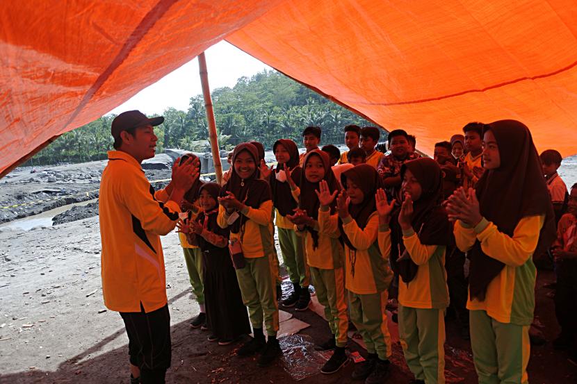 Siswa SDN Jugosari 3 belajar di tenda di pinggir Sungai Regoyo, Desa Jugosari, Candipuro, Lumajang, Jawa Timur.