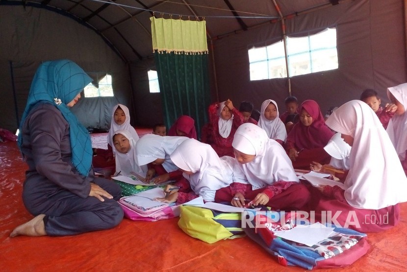 Siswa SDN Sukasari, Kelurahan Gunung Tandala, Kecamatan Kawalu, Kota Tasikmalaya, Jawa Barat belajar di tenda, Rabu (3/1). Sekolah mereka mengalami kerusakan akibat gempa pertengahan Desember lalu.