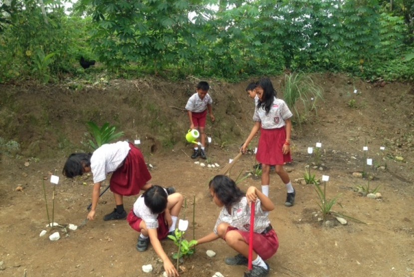 Siswa sekolah dasar di sekitar kawasan Danau Toba sedang merawat dan melestarikan kawasan sekolah dengan menanam tanaman obat dan buah. 