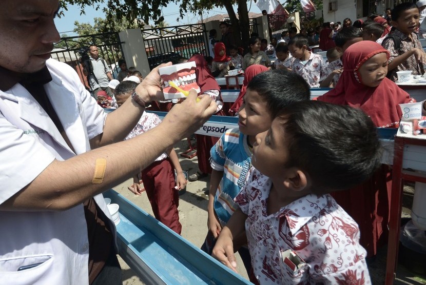 Siswa Sekolah Dasar memperhatikan cara menyikat gigi yang baik saat mengikuti kegiatan Bulan Kesehatan Gigi Nasional (BKGN) 2015 di Rumah Sakit Gigi & Mulut Kandea Universitas Hasanuddin, Makassar, Sulawesi Selatan, Kamis (8/10). 