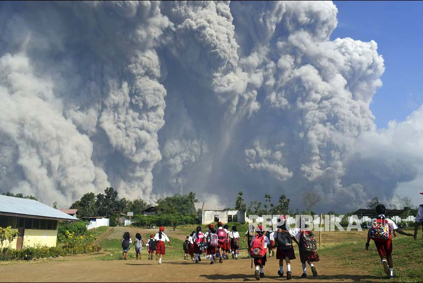 Siswa sekolah dasar menonton letusan gunung Sinabung yang memuntahkan material vulkanis di Karo, Sumatra Utara.