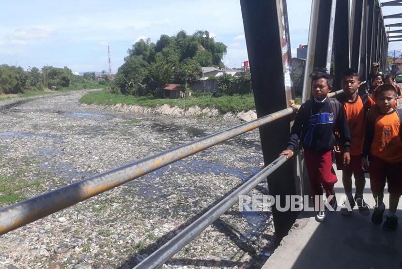 Siswa Sekolah Dasar tengah berjalan kaki di jembatan Citarum lama, Senin (19/2). Kondisi sungai Citarum lama yang tidak aktif dipenuhi dengan sampah dan air limbah pabrik.