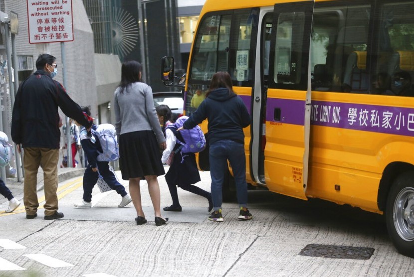 Siswa sekolah dasar turun dari bus sekolah di Hong Kong, Rabu (20/11). Sekolah di Hong Kong dibuka kembali setelah ditutup beberapa hari akibat protes.